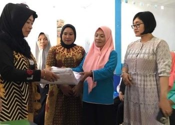 Pelaksana Bidang Keluarga Berencana dan Keluarga Sejahtera (KB - KS), Sarkiya Nani saat menyalurkan bantuan BKB Kit dan Jasa Transportasi TPK di Balai Penyuluh KB Bonepantai, Jumat (27/10/2023). (Foto Indra/Gopos)