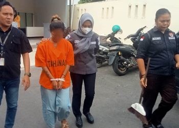 SB alias Melisa yang menjadi tersangka dugaan penganiayaan terhadap anak tiri digiring oleh petugas Polresta Gorontalo Kota, Selasa (12/12/2023).