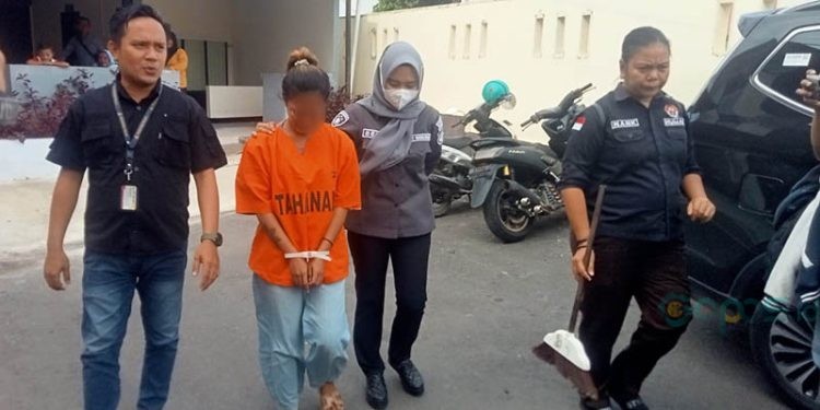 SB alias Melisa yang menjadi tersangka dugaan penganiayaan terhadap anak tiri digiring oleh petugas Polresta Gorontalo Kota, Selasa (12/12/2023).
