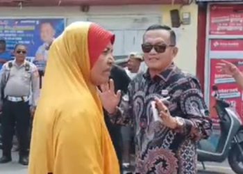 Caleg Ekwan Ahmad (batik) berkomunikasi dengan seorang ibu yang mengadang rombongannya saat hendak menuju ke Kelurahan Tanjung Keramat, Kota Gorontalo. (istimewa)