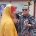 Caleg Ekwan Ahmad (batik) berkomunikasi dengan seorang ibu yang mengadang rombongannya saat hendak menuju ke Kelurahan Tanjung Keramat, Kota Gorontalo. (istimewa)
