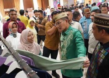 Menparekraf, Sandiaga Uno, didampingi Kepala Perwakilan Bank Indonesia provinsi Gorontalo, Dian Nugraha, melihat produk fesyen UMKM mitra binaan BI Gorontalo. (dok. Putra/BI Gorontalo)
