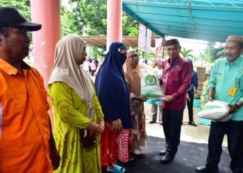 Bupati Pohuwato, Saipul Mbuinga Memberikan Bantuan Beras Gratis Secara Simbolis Kepada Salah Satu KPM, berlangsung di halaman dinas pangan Pohuwato, Kamis (1/2/2024). (F Humas Pemda Pohuwato)