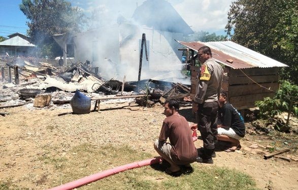 Tampak petugas kepolisian saat berusaha memadamkan api pada peristiwa kebakaran dua rumah di Kecamatan Popayato, Kabupaten Pohuwato, Rabu (20/2/2024).