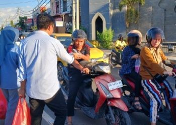 Sekretaris DPD Gerindra Provinsi Gorontalo, Muhammad Nasir Majid ikut membagikan takjil ramadan kepada masyarakat di Simpang Lima Telaga, Ahad (24/3/2024) (muhajir/gopos)