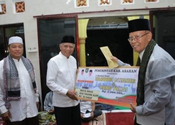 Bupati Asahan Surya menyerahkan bantuan secara simbolis kepada KPM Al Ikhlas pada kegiatan Safari Ramadan, Kamis (21/3/2024).