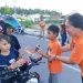 Salah satu anak-anak dari jemaat kristen membagikan takjil kepada pengendara yang melintas di Komplek Blok Plan Perkantoran Marisa.