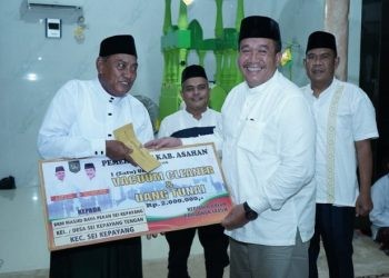 Wakil Bupati Asahan Taufik Zainal Abidin Siregar saat menyerahkan bantuan secara simbolis kepada BKM Sei Kepayang pada Safari Ramadan Perdana, Senin malam (18/3/2024).