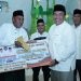 Wakil Bupati Asahan Taufik Zainal Abidin Siregar saat menyerahkan bantuan secara simbolis kepada BKM Sei Kepayang pada Safari Ramadan Perdana, Senin malam (18/3/2024).