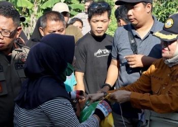 Bupati Merlan S. Uloli saat melayani warga yang membeli beras premium pada pelaksanaan pasar murah di Pasar Jumat Tumbihe, Jumat (1/3/2024). (Foto AKP/Diskominfo