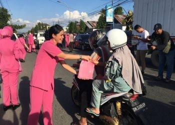 Ketua Bhayangkari Bone Bolango, Ny Cindy M. Alli bersama para anggotanya saat membagikan takjil berbuka puasa kepada masyarakat yang melintasi jalan depan Polsek Kabila, Selasa (19/3/2024). (Foto Indra/Gopos)