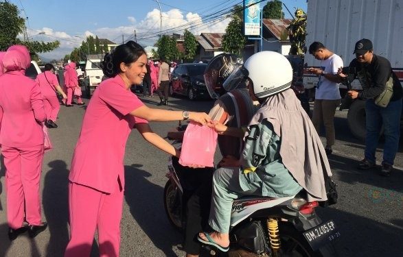 Ketua Bhayangkari Bone Bolango, Ny Cindy M. Alli bersama para anggotanya saat membagikan takjil berbuka puasa kepada masyarakat yang melintasi jalan depan Polsek Kabila, Selasa (19/3/2024). (Foto Indra/Gopos)