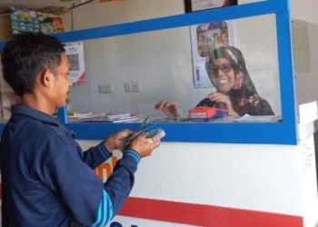Ellen P. Tahuhe melayani transaksi keuangan nasabah di Agen BRILink miliknya yang berlokasi di Jl. Pramuka, Kelurahan Bulotadaa, Kota Gorontalo. (muhajir/gopos)