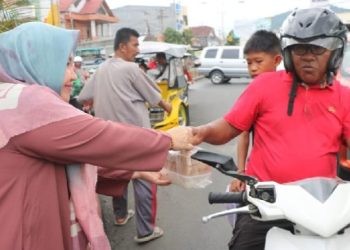 Ketua PIAD Rena Olii Wartabone membagikan paket makanan berbuka puasa kepada masyarakat Gorontalo, Jumat (22/3/2024) (muhajir/gopos)