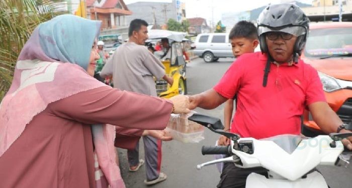 Ketua PIAD Rena Olii Wartabone membagikan paket makanan berbuka puasa kepada masyarakat Gorontalo, Jumat (22/3/2024) (muhajir/gopos)