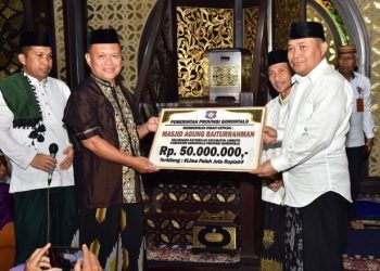 Penjagub Gorontalo Ismail Pakaya saat menyerahkan secara simbolis dana hibah Pemprov Gorontalo kepada takmirul Masjid Baiturrahman Limboto.(F. Humasprov)