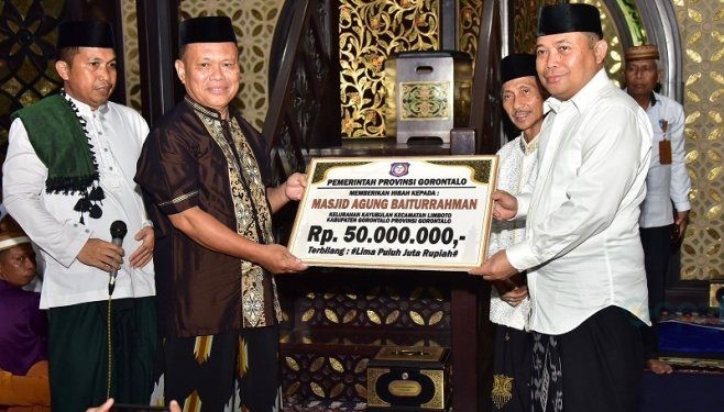 Penjagub Gorontalo Ismail Pakaya saat menyerahkan secara simbolis dana hibah Pemprov Gorontalo kepada takmirul Masjid Baiturrahman Limboto.(F. Humasprov)