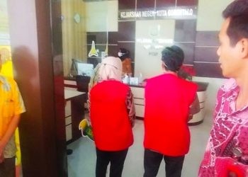 Tersangka ZM dan DA selaku pejabat di Dinas PUPR Kota Gorontalo saat ditetapkan sebagai tersangka di Kejari Kota Gorontalo, Jumat (22/3/2024).(F. Putra/gopos)