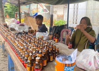 Zenab pedagang lampu minyak untuk tradisi Tumbilotohe di Gorontalo menyiapkan sedikitnya 5.000 botol untuk dijual.(F. Aas/gopos)