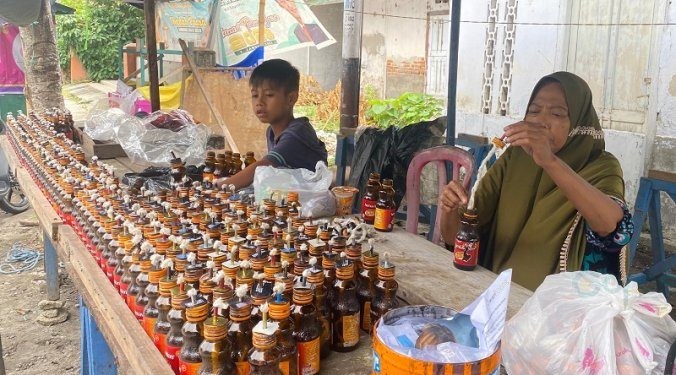 Zenab pedagang lampu minyak untuk tradisi Tumbilotohe di Gorontalo menyiapkan sedikitnya 5.000 botol untuk dijual.(F. Aas/gopos)