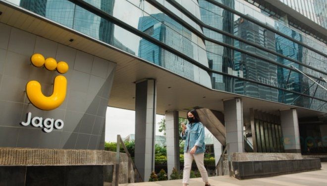 Seorang wanita berjalan di depan kantor Bank Jago. (ANTARA/Citro Atmoko)