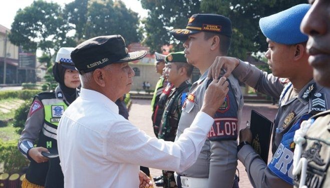 Bupati Asahan Surya saat menyematkan pin pada apel gelar pasukan Keselamatan Toba 2024, Rabu (13/3/2024).