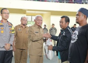 Bupati Asahan, Surya saat membagikan bantuan beras secara simbolis kepada kaum dhuafa.