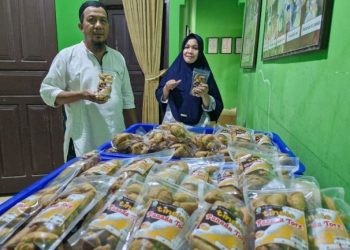 Aty Tumayahu dan Amrin Ikhsan bersama produk Panada Tore Tinelo yang biasa dijual di gerai Alfamart Gorontalo.(F. Hervi)