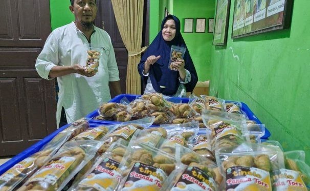 Aty Tumayahu dan Amrin Ikhsan bersama produk Panada Tore Tinelo yang biasa dijual di gerai Alfamart Gorontalo.(F. Hervi)