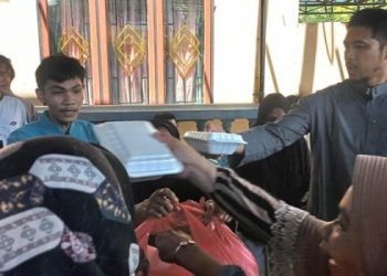 Fais Nemsa (kanan) membagikan makanan siap saji kepada jemaah masjid Al-Musyafirin dalam kegiatan Jumat Berkah, Jumat (10/5/2024)