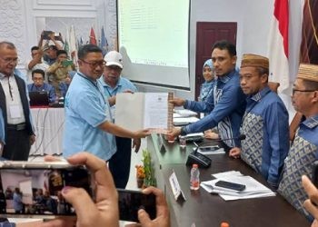 Ketua KPU Kota Gorontalo, Muhammad Fadly Thaib, menyerahkan berita acara serah terima dokumen syarat dukungan paslon persorangan, Adhan Dambea-Indra Gobel, Jumat (10/5/2024).