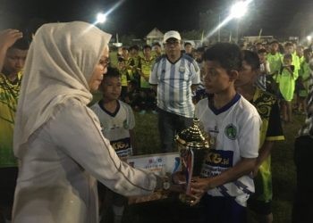 Bupati Merlan S. Uloli saat menyerahkan trophy juara 1 untuk Kecamatan Tapa Bulango pada ajang talenta GSI jenjang SMP tingkat Kabupaten Bone Bolango, Minggu (5/5/2024) malam. (Foto Indra/Gopos)