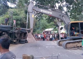 Sebuah kendaraan alat berat dikerahkan untuk mengevakuasi truk kontainer di jalan Trans Sulawesi Desa Pontolo, Kecamatan Kwandang, Kabupaten Gorontalo Utara yang menyebabkan seorang pengemudi sepeda motor tewas di tempat, Minggu (5/5/2024).