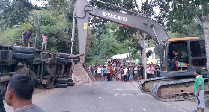 Sebuah kendaraan alat berat dikerahkan untuk mengevakuasi truk kontainer di jalan Trans Sulawesi Desa Pontolo, Kecamatan Kwandang, Kabupaten Gorontalo Utara yang menyebabkan seorang pengemudi sepeda motor tewas di tempat, Minggu (5/5/2024).