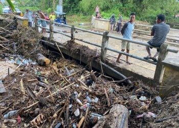 Salah satu jembatan di Kelurahan Hepuhulawa, Kecamatan Limboto tertutup material dan ranting pohon sehingga membuat air meluap ke pemukiman warga setempat, Senin (27/5/2024).(Foto Abin/gopos)