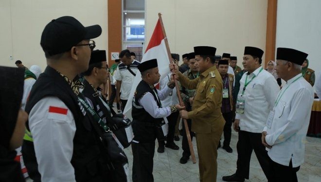 Pj Gubernur Sumut Hassanudin saat melepas jemaah calon haji kloter 1 Asahan secara simbolis dengan menyerahkan bendera kepada petugas haji di Asrama Haji Medan, Senin (13/5/2024)