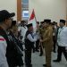 Pj Gubernur Sumut Hassanudin saat melepas jemaah calon haji kloter 1 Asahan secara simbolis dengan menyerahkan bendera kepada petugas haji di Asrama Haji Medan, Senin (13/5/2024)