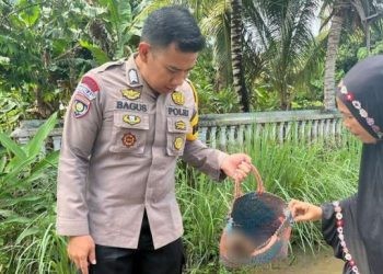 Bhabinkamtibmas Bripka Budhi Bagus saat memperlihatkan tulang belulang manusia yang ditemukan warga pasca banjir bandang di Kelurahan Hunggaluwa, Kecamatan Limboto, Kabupaten Gorontalo, Senin (27/5/2024).