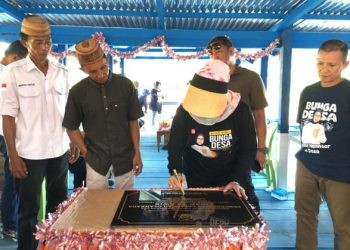 Bupati Merlan S. Uloli didampingi tokoh masyarakat Suwawa Tengah, Arifin Maliwu saat menandatangani prasasti peresmian lapangan bola voli. (Foto Indra/Gopos)