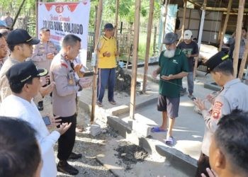 Kapolres Bone Bolango, AKBP Muhammad Alli saat melakukan peletakan batu pertama bedah rumah keluarga Jufri Bahua di Kecamatan Botupingge. (Foto Humas Polres Bone Bolango)