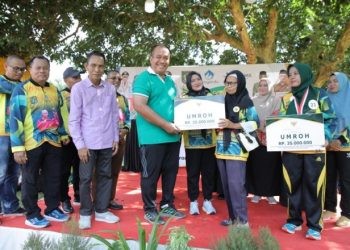 Wakil Bupati Asahan Taufik Zainal Abidin Siregar saat menyerahkan secara simbolis hadiah utama berupa paket umrah kepada kader berprestasi pada Jambore Kader Posyandu ke 11 Tingkat Kabupaten Asahan Tahun 2024.