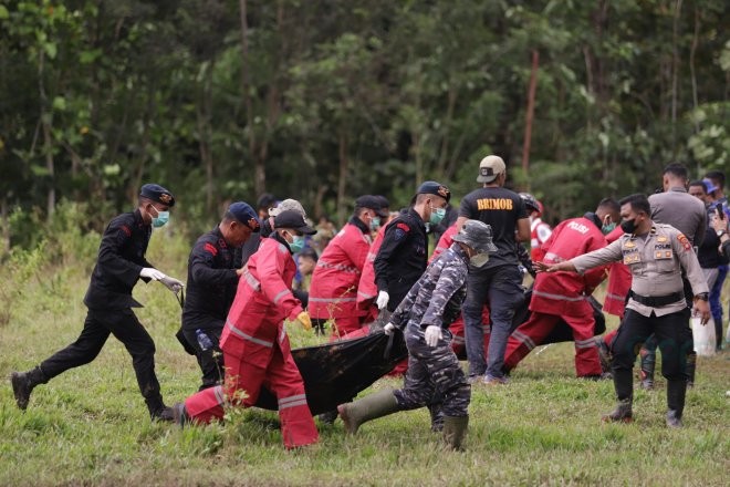 Tim evakuasi saat memindahkan korban longsor yang meninggal dari helikopter ke tempat pemandian jenazah. (Foto Adit)