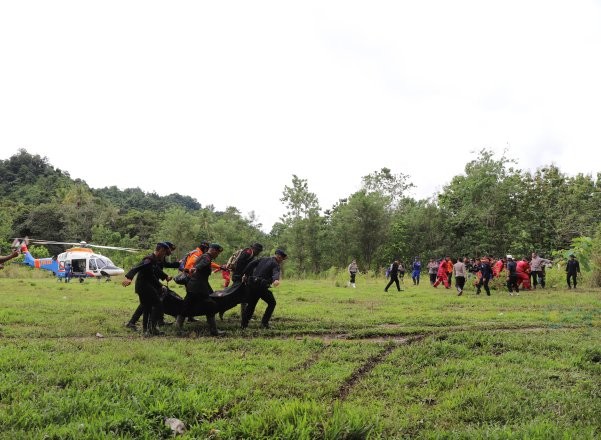 Tim evakuasi saat memindahkan jenazah korban longsor Suwawa Timur dari Helikopter ke tempat pemandian jenazah. (Foto Adit)