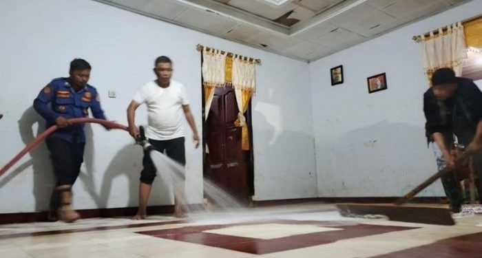 Tim Pemkab Gorontalo yang dipimpin oleh Plh Sekda, Haris Tome sedang membersihkan rumah warga yang terdamoak banjir di Dungaliyo. (Foto: Istimewa)