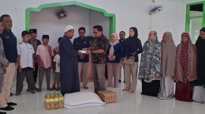 Ketua KPU Gorontalo Utara Sofyan Jakfar saat menyerahkan santunan kepada pengurus panti asuhan Al-Izzah Desa Mootinelo, Kecamatan Kwandang, Selasa (16/7/2024).