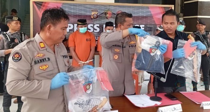 Kapolres Pohuwato AKBP Winarno (tengah) saat menunjukkan barang bukti kasus pembunuhan di jalan trans Sulawesi kompleks SPBU Marisa, Selasa (16/7/2024).(Foto Yusup/gopos)