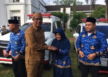 Penjabat Sekda Bone Bolango, Aznan Nadjamudin saat menyerahkan bantuan mobil ambulan kepada delapan puskesmas, Senin (22/7/2024). (Foto Indra/Gopos)