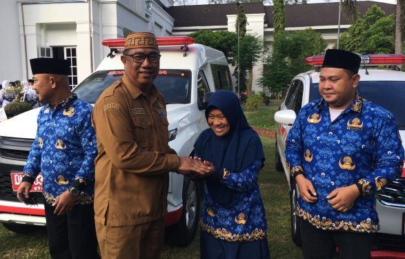 Penjabat Sekda Bone Bolango, Aznan Nadjamudin saat menyerahkan bantuan mobil ambulan kepada delapan puskesmas, Senin (22/7/2024). (Foto Indra/Gopos)