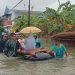 Beberapa orang warga mengevakuasi seorang ibu rumah tangga dan balita menggunakan rakit seadanya pada banjir di wilayah Kota Gorontalo, Kamis (11/7/2024). (Foto Sari/gopos)