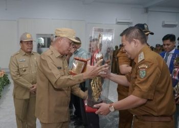 Bupati Asahan Surya saat menyerahkan piala kepada Desa Terbaik 2024.